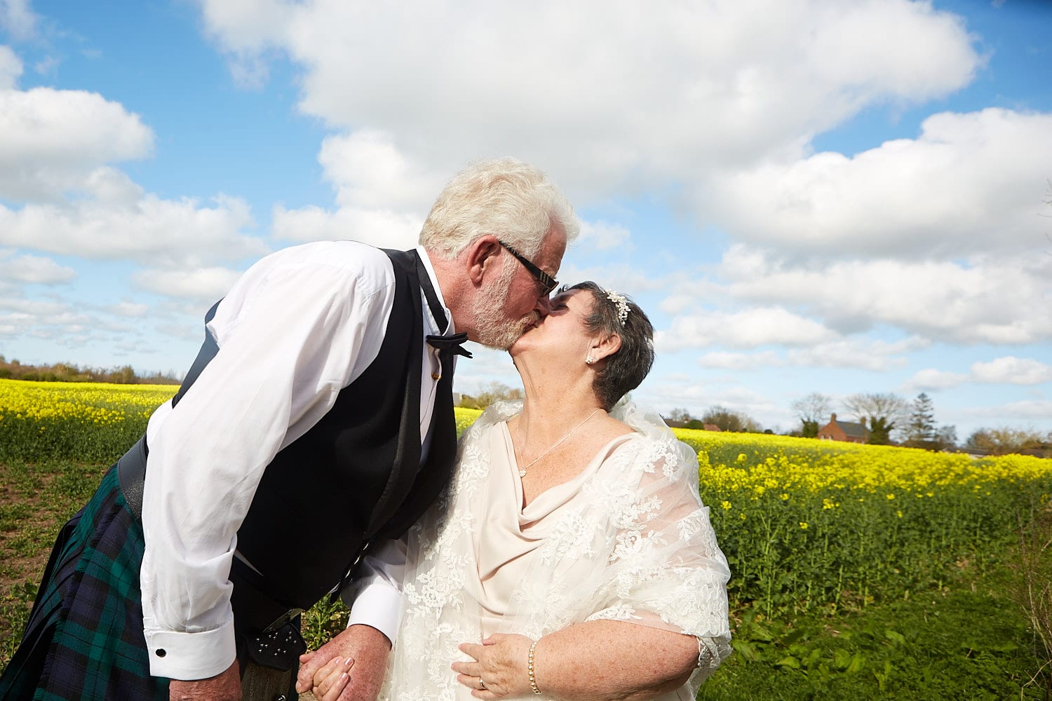 An older, just married couple kiss.