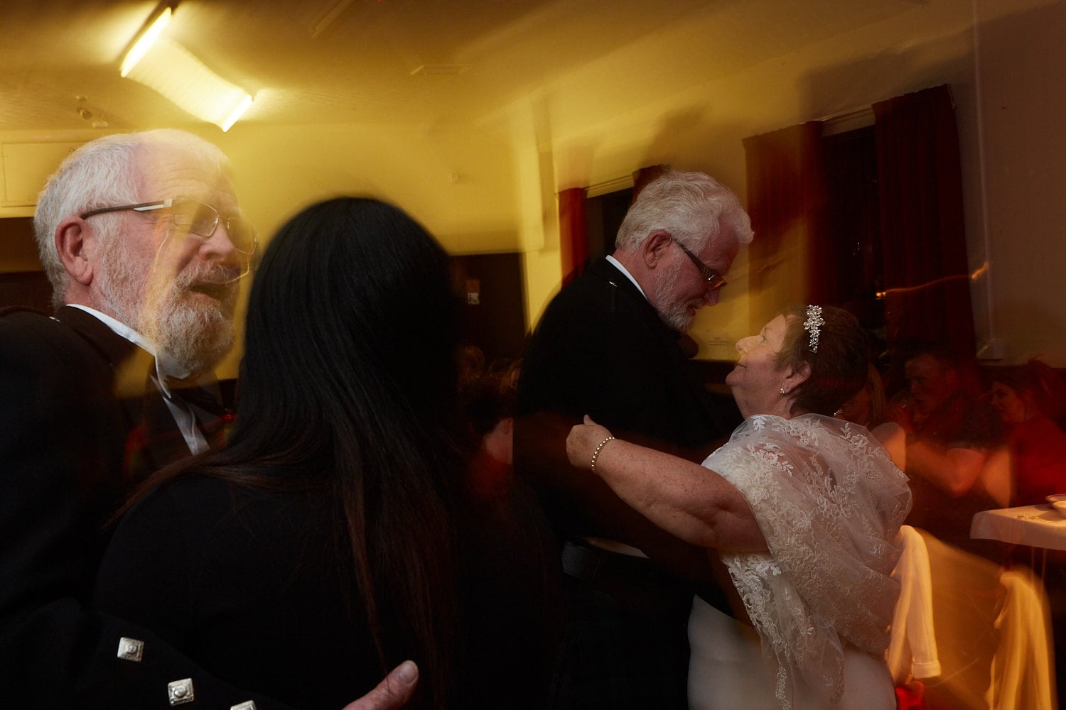 A bride & groom along with the best man and his granddaughter dance at a wedding reception