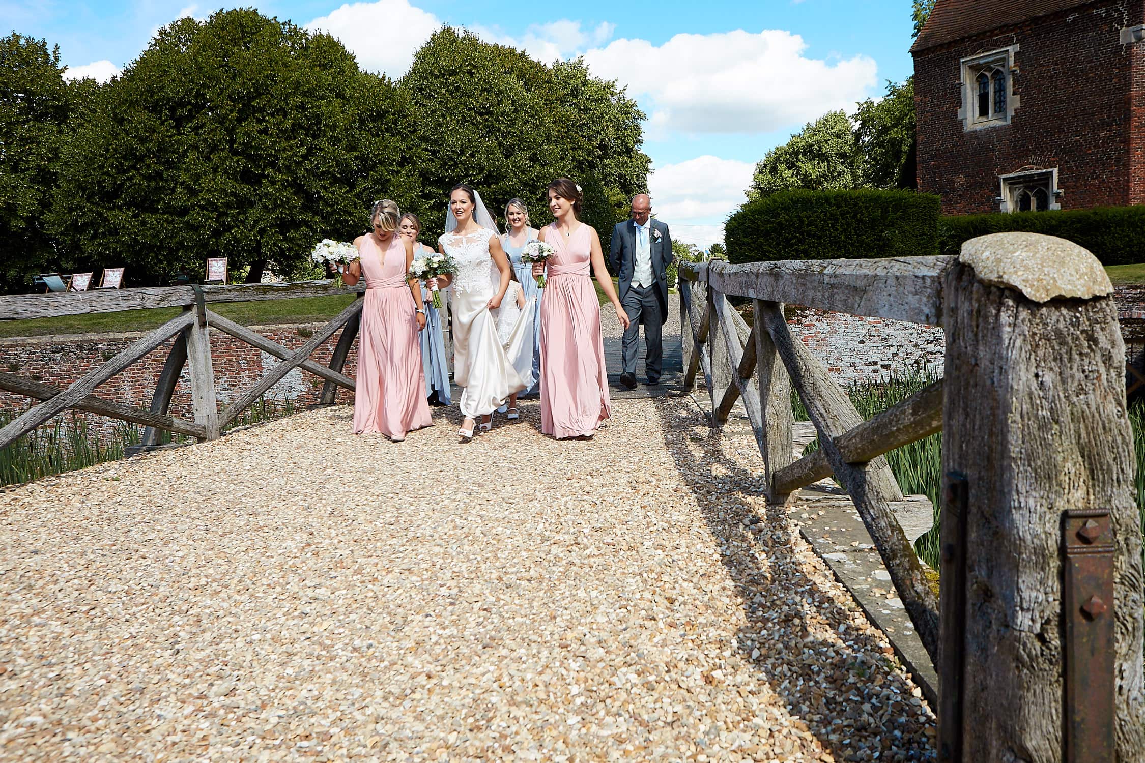 A bride and her bridesmaids walk towards Tattershall Castle
