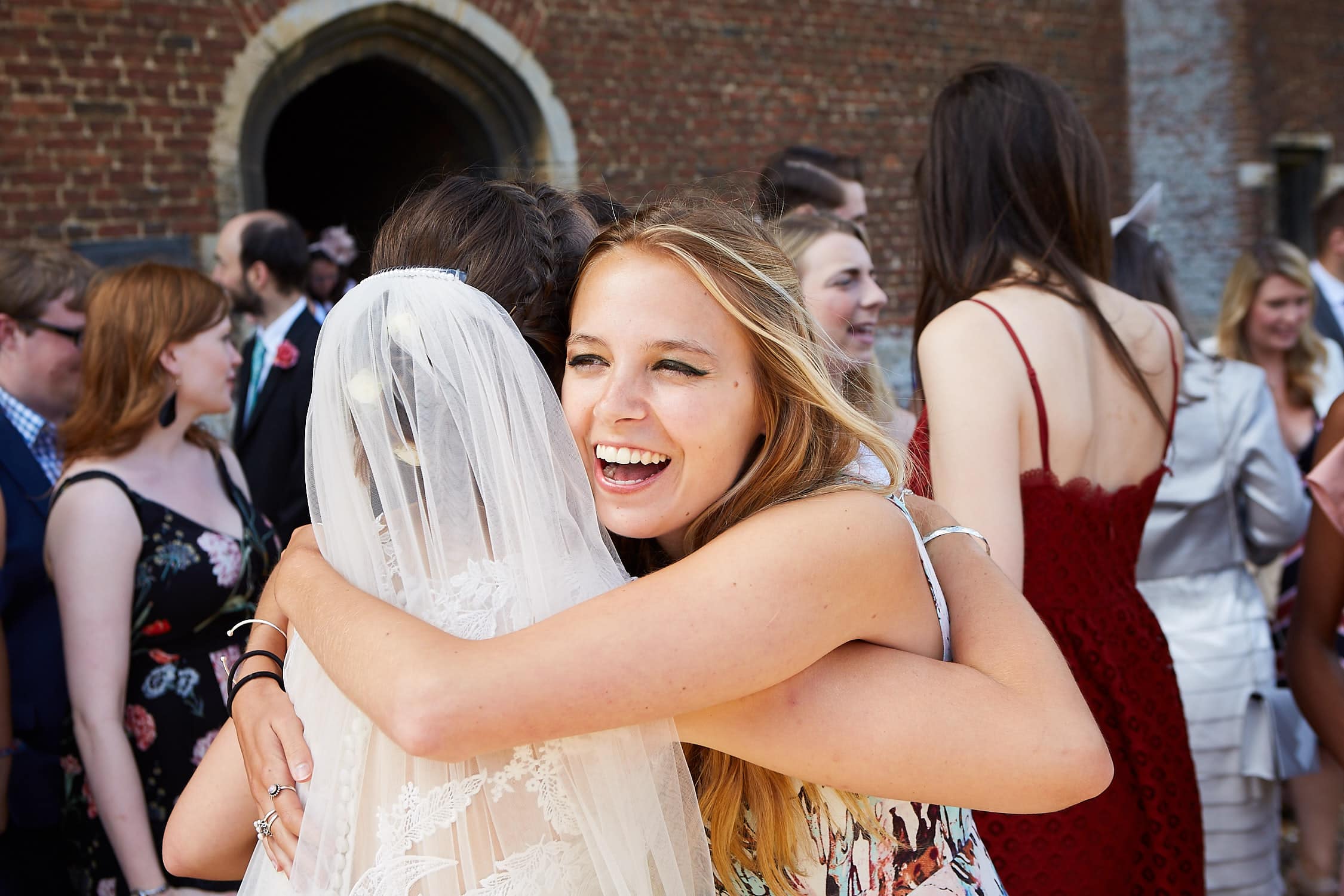 Hugging a bride a guest smiles
