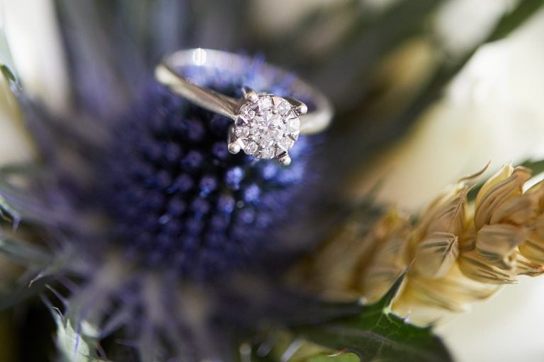 A diamond engagement ring placed amongst flowers