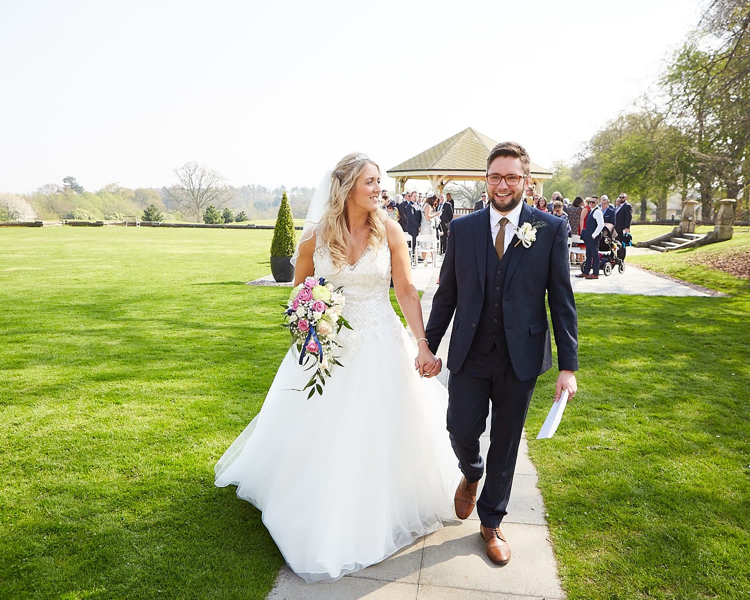 A newly married couple walking together outdoors at Kenwick Park Hotel Louth