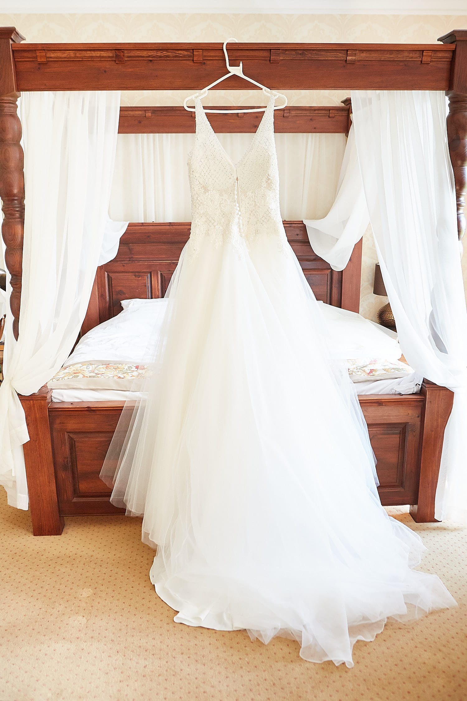 A dress hanging from a four poster bed