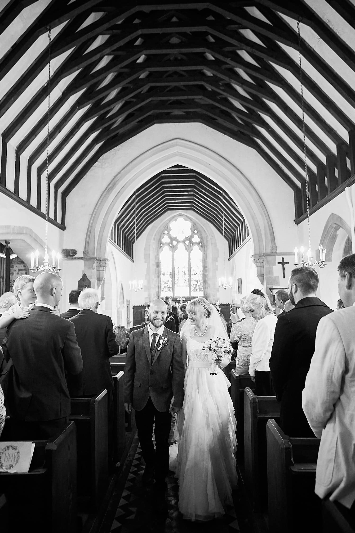 A couple leave St Peters Church at their Gunby Hall Wedding