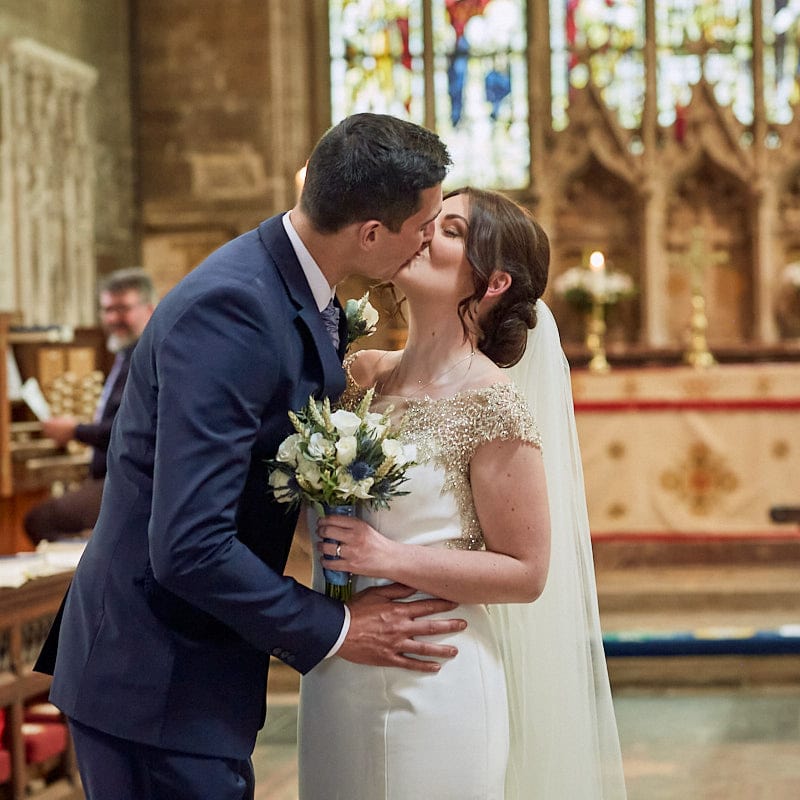 A couple kiss inside a Lincolnshire Church on their wedding day.