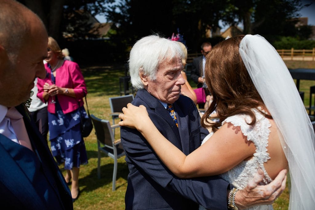 AS grandfather embraces his daughter with complete adoration on her wedding day.