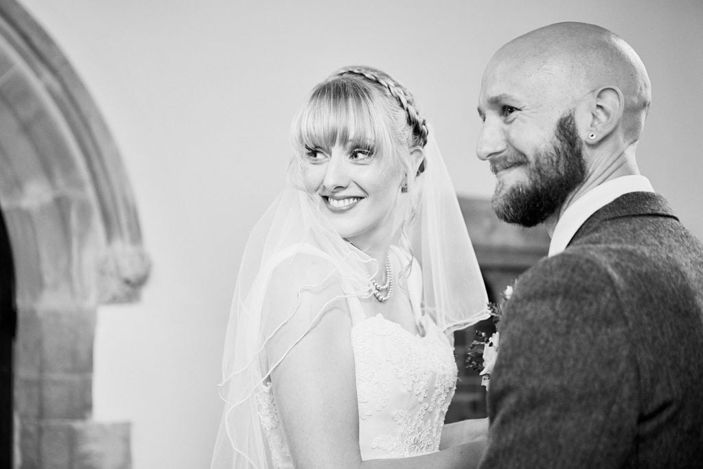 A couple look back to their guests from the from of the church at Gunby Hall
