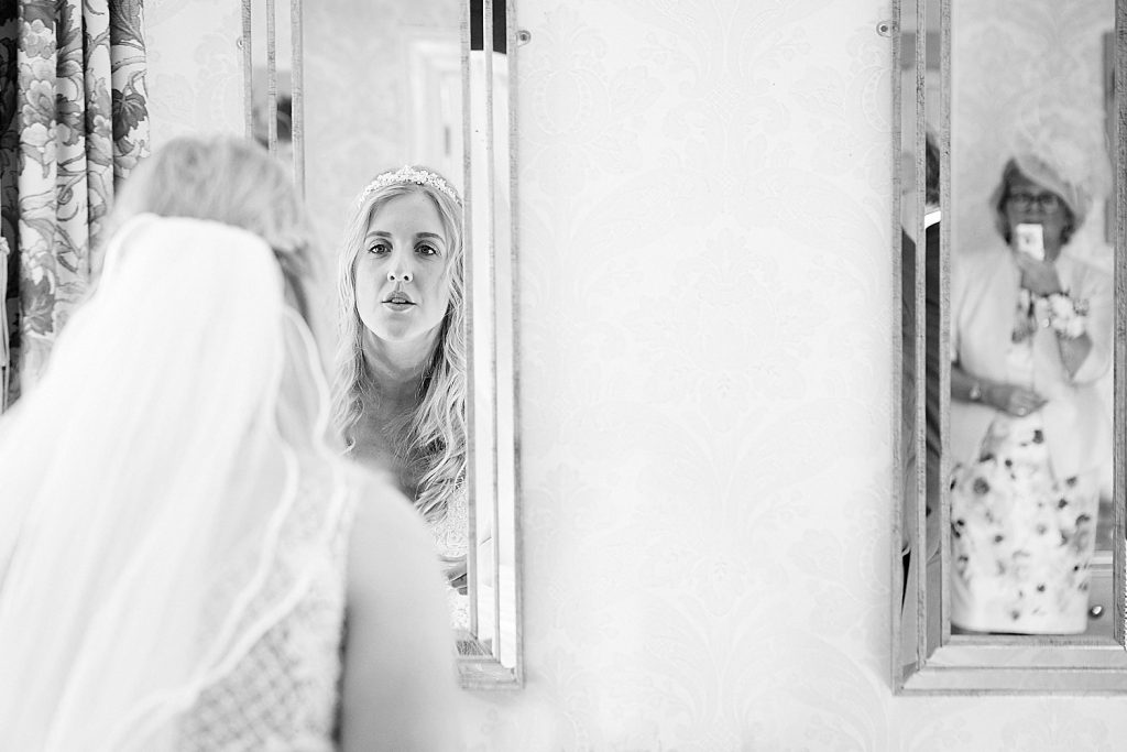 A bride touches her makeup up whilst her mom snaps a photo on an iPhone