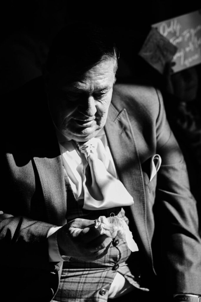 A black and white photo of the father of the groom as he is overcome by emotion.